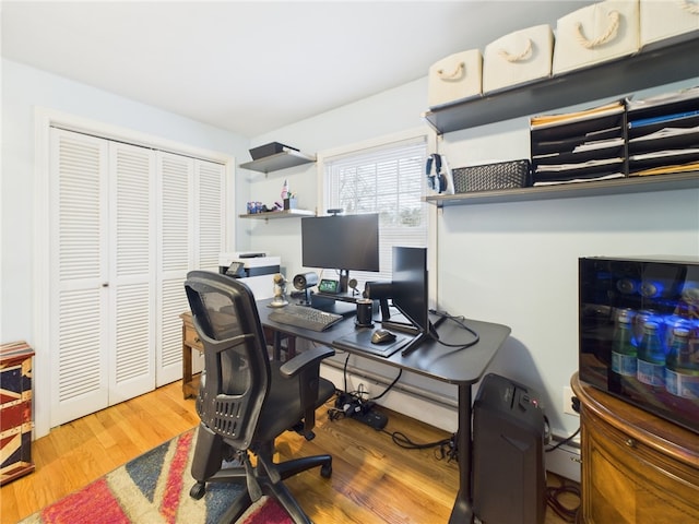 home office with a baseboard heating unit and wood finished floors