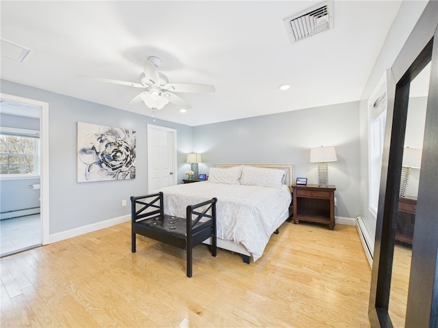 bedroom featuring baseboards, visible vents, a baseboard radiator, light wood-style flooring, and baseboard heating