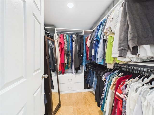 walk in closet with wood finished floors