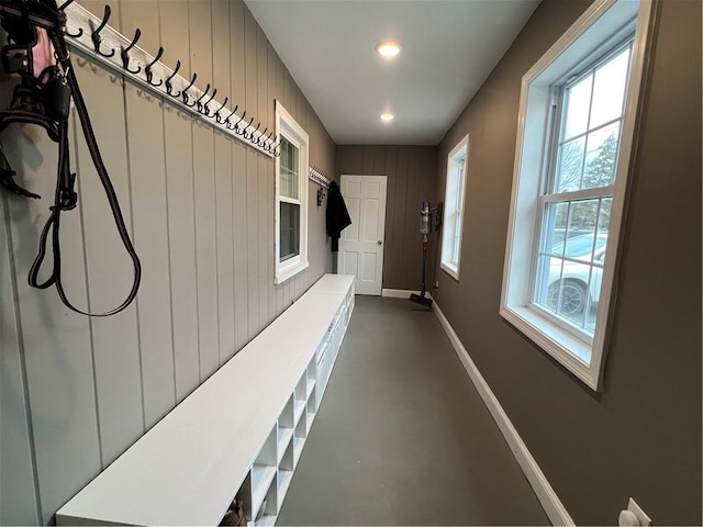 hallway featuring recessed lighting, baseboards, and concrete flooring