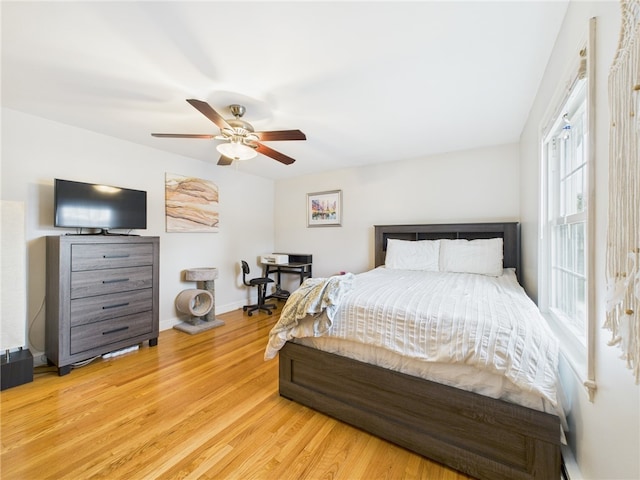 bedroom with a ceiling fan, baseboards, and wood finished floors