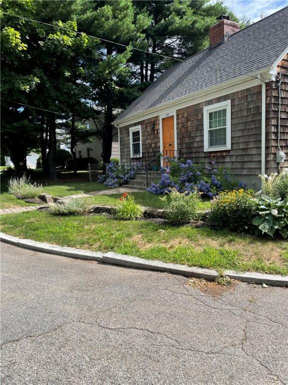 view of front of house with roof with shingles and a chimney