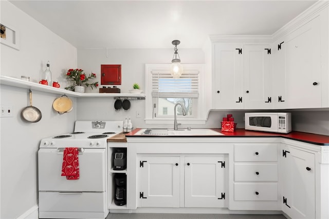 kitchen with dark countertops, white cabinets, white appliances, and a sink