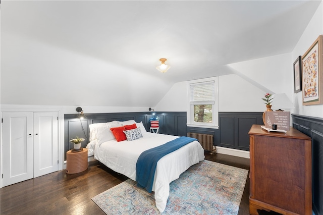 bedroom featuring vaulted ceiling, radiator heating unit, and wood finished floors