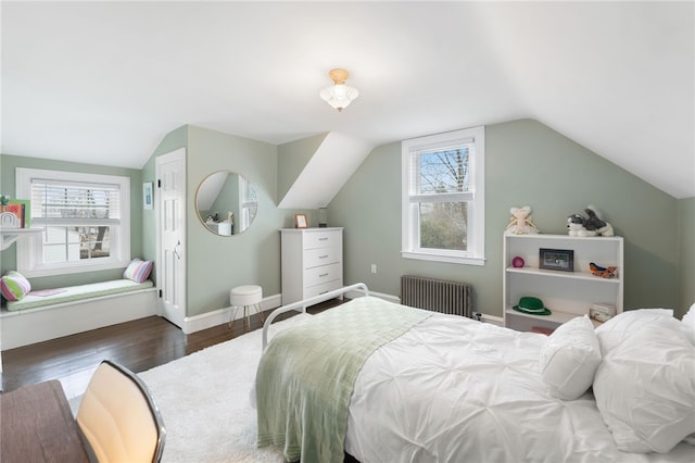 bedroom featuring baseboards, lofted ceiling, wood finished floors, and radiator heating unit