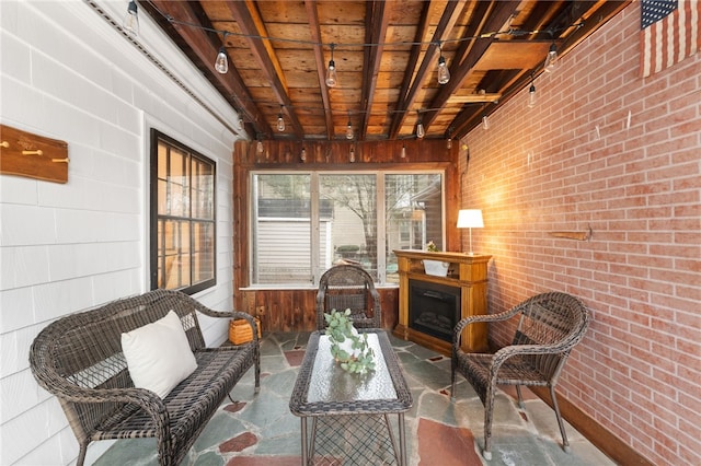 sunroom / solarium featuring a fireplace, beam ceiling, and wood ceiling