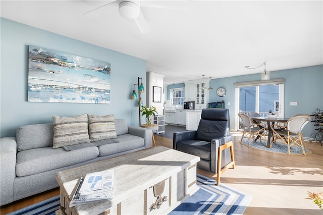 living room with light wood-style floors and a ceiling fan