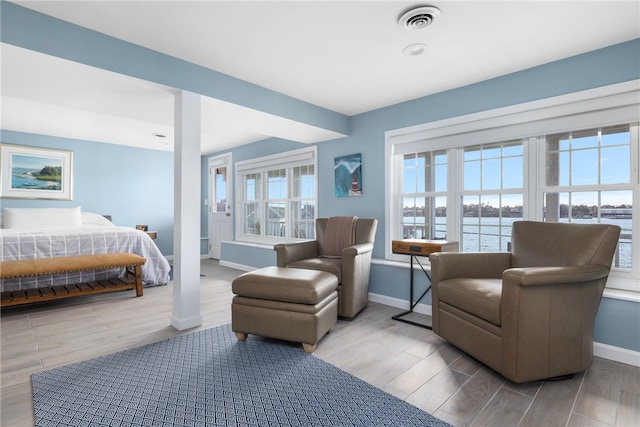 bedroom featuring wood finish floors, visible vents, and baseboards