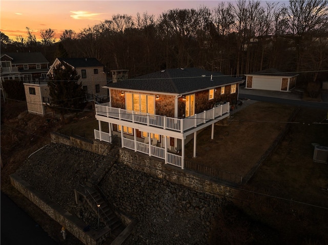 rear view of property featuring an outdoor structure and a balcony