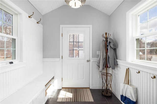 mudroom featuring vaulted ceiling, dark tile patterned flooring, and a wainscoted wall