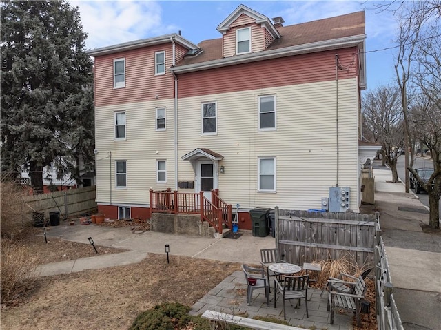 rear view of house with a patio area and fence