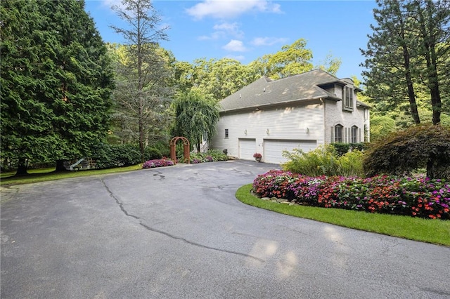 view of side of home featuring a garage and driveway