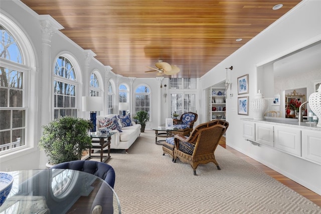 sunroom featuring wood ceiling and ceiling fan