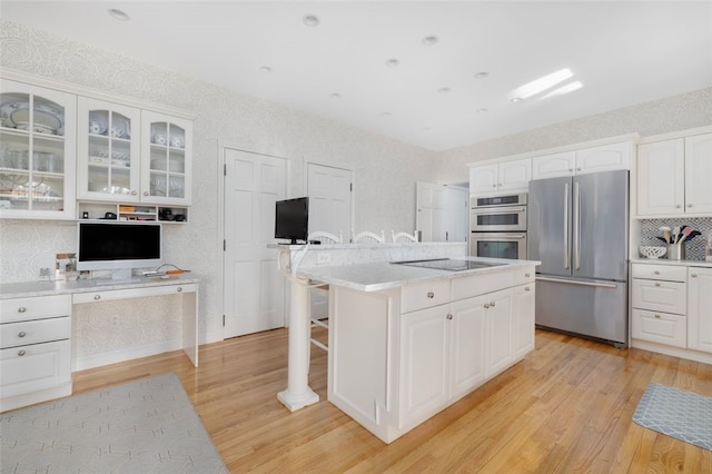 kitchen featuring glass insert cabinets, white cabinets, appliances with stainless steel finishes, and light wood-style flooring