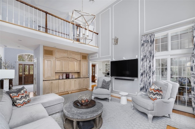 living area with a chandelier, baseboards, and a towering ceiling