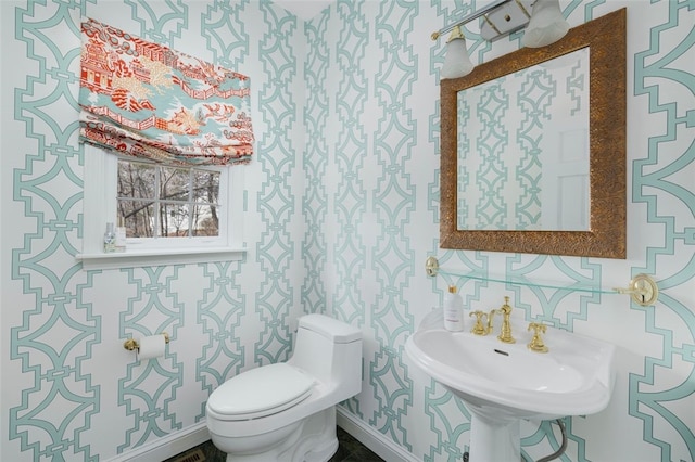 bathroom featuring toilet and baseboards