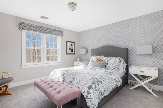 bedroom with visible vents, carpet flooring, wallpapered walls, baseboards, and an accent wall