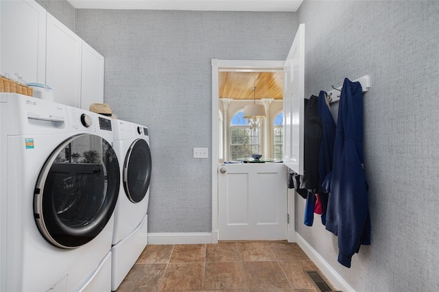 washroom with wallpapered walls, visible vents, cabinet space, and washing machine and clothes dryer