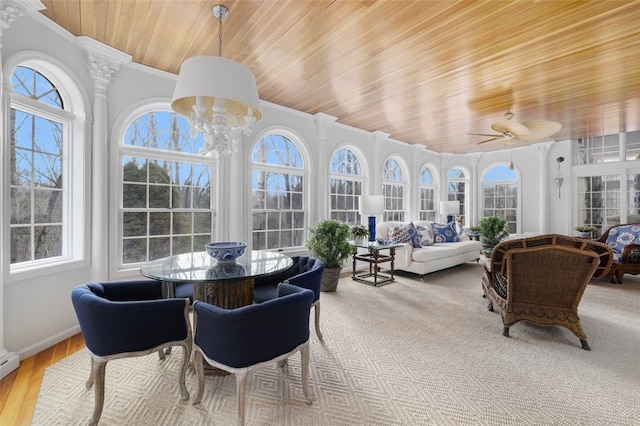 sunroom featuring ceiling fan with notable chandelier, wooden ceiling, and ornate columns