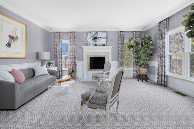 living room with a wainscoted wall, visible vents, ornamental molding, carpet, and a fireplace