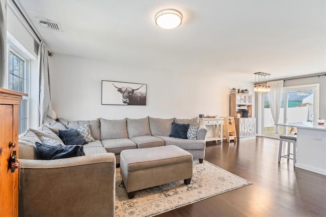 living room with dark wood-style floors and visible vents