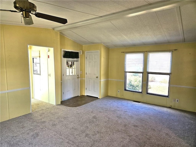 carpeted empty room with vaulted ceiling with beams, visible vents, and ceiling fan