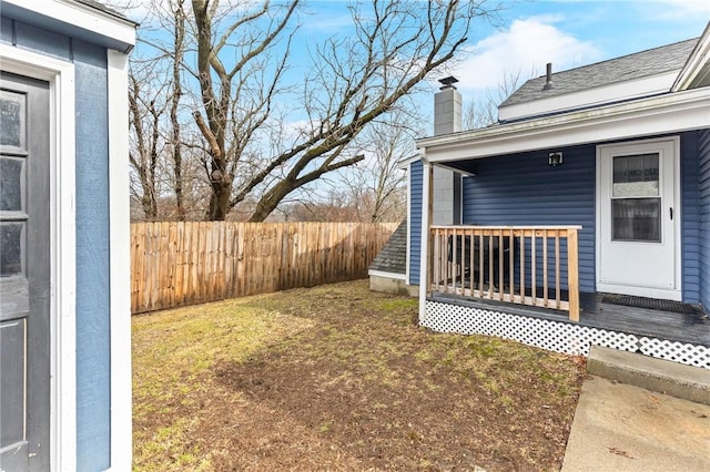 view of yard featuring covered porch and fence