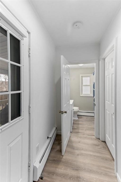 hallway with light wood-style flooring and a baseboard radiator