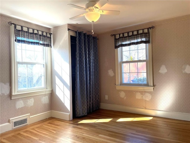 unfurnished dining area with wallpapered walls, plenty of natural light, and visible vents