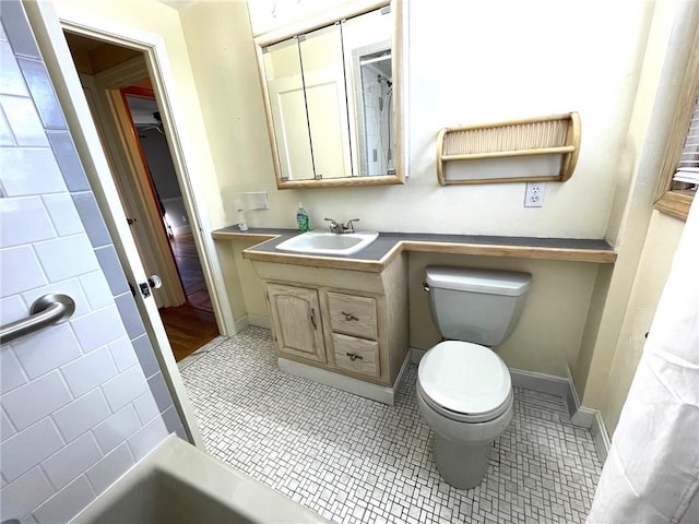 bathroom with tile patterned floors, baseboards, toilet, and vanity