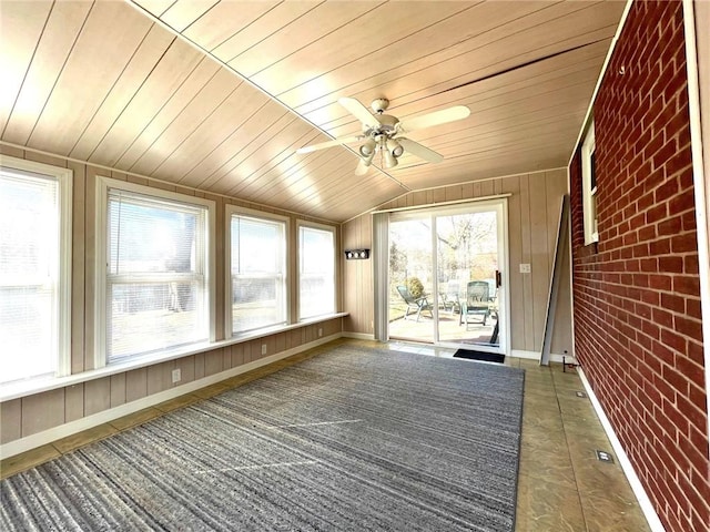 unfurnished sunroom featuring ceiling fan, wood ceiling, and lofted ceiling