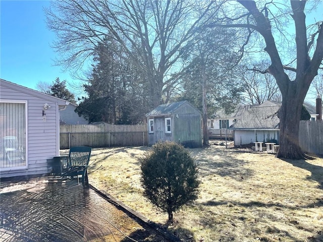 view of yard with an outbuilding, a storage unit, and fence