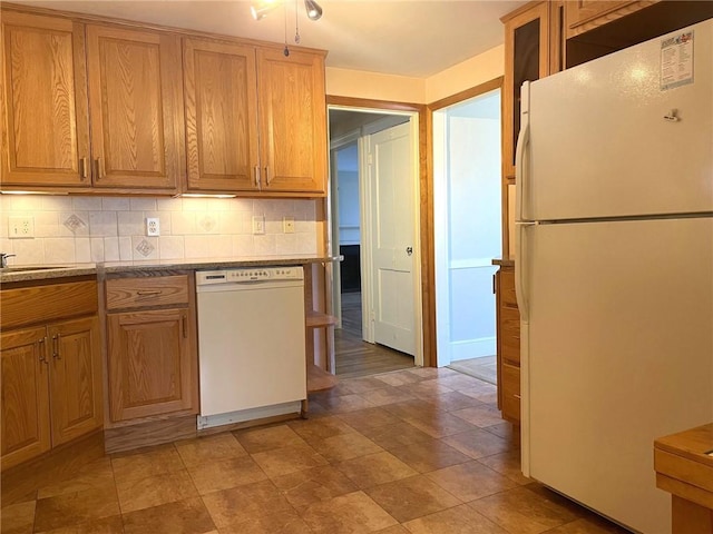 kitchen with decorative backsplash, white appliances, and brown cabinetry