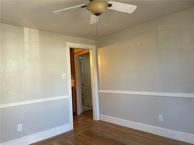 unfurnished room featuring baseboards, wood finished floors, and a ceiling fan