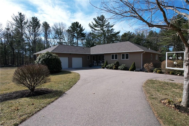 ranch-style home with aphalt driveway and a garage