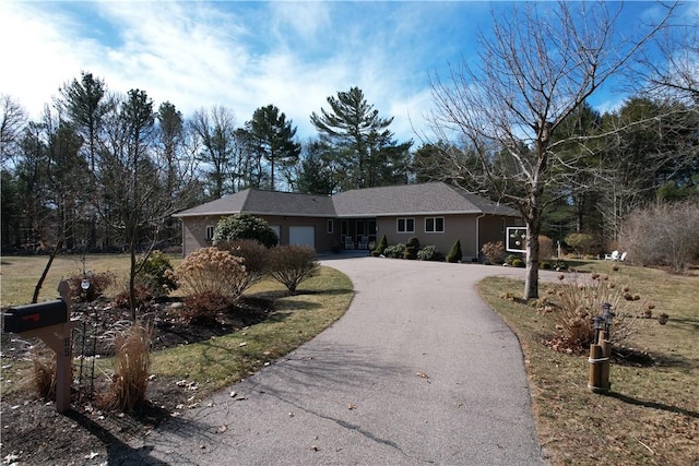 ranch-style house featuring a garage and driveway