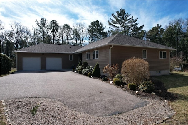 ranch-style home featuring driveway, a shingled roof, and a garage