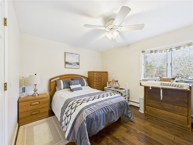 bedroom with a ceiling fan, wood finished floors, and baseboard heating