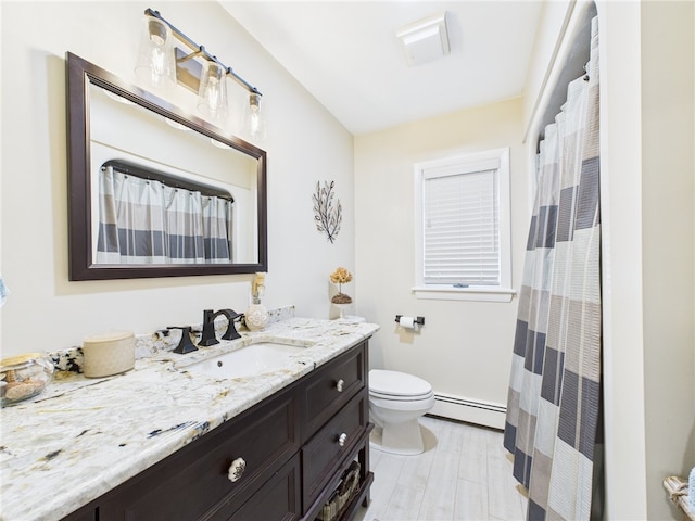 bathroom featuring vanity, toilet, and baseboard heating