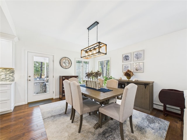 dining area with dark wood finished floors, baseboards, a wealth of natural light, and a baseboard heating unit