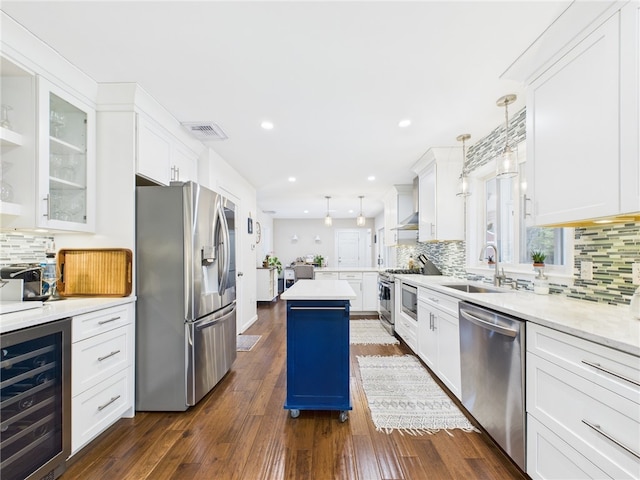 kitchen featuring visible vents, beverage cooler, a sink, appliances with stainless steel finishes, and light countertops