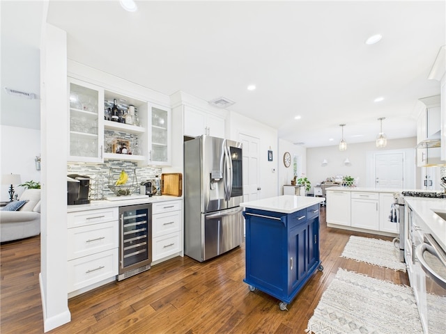 kitchen with blue cabinetry, wine cooler, appliances with stainless steel finishes, and white cabinets