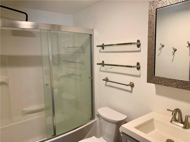 full bathroom featuring combined bath / shower with glass door, toilet, and vanity