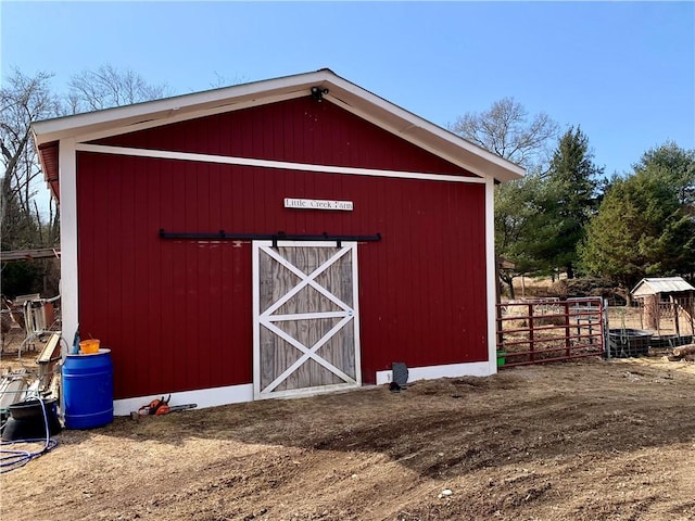 view of barn featuring fence