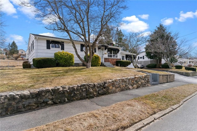 ranch-style house featuring a front yard and fence