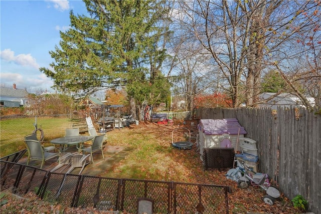 view of yard with an outbuilding, a storage shed, and a fenced backyard