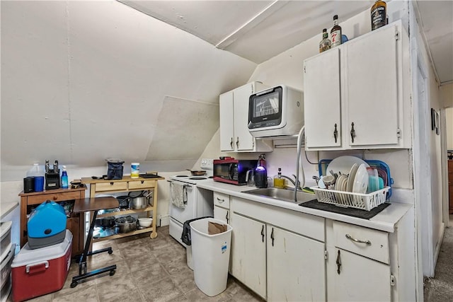 kitchen with white electric range oven, a sink, light countertops, white cabinets, and vaulted ceiling