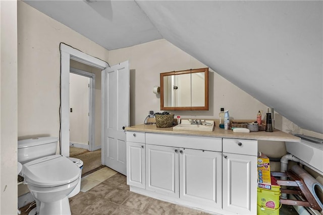 bathroom with toilet, vanity, and lofted ceiling