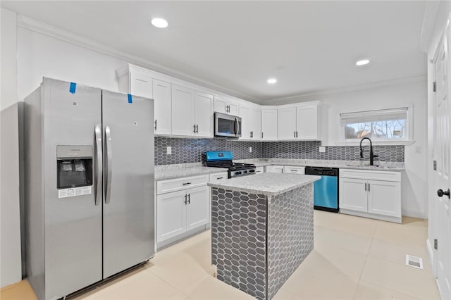 kitchen with a sink, appliances with stainless steel finishes, white cabinets, crown molding, and decorative backsplash