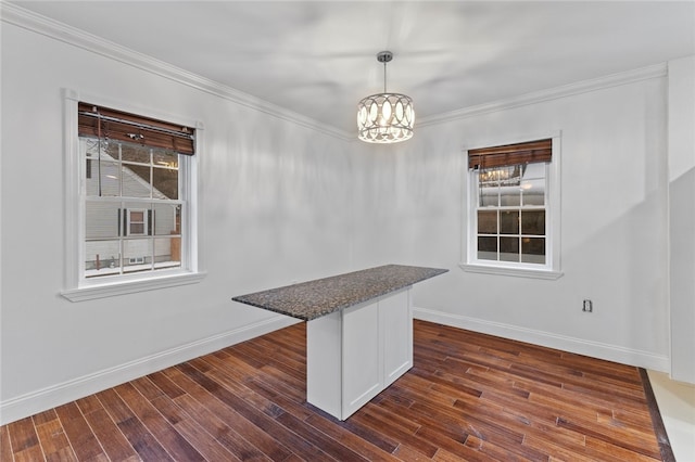 unfurnished dining area featuring dark wood-type flooring, plenty of natural light, baseboards, and ornamental molding